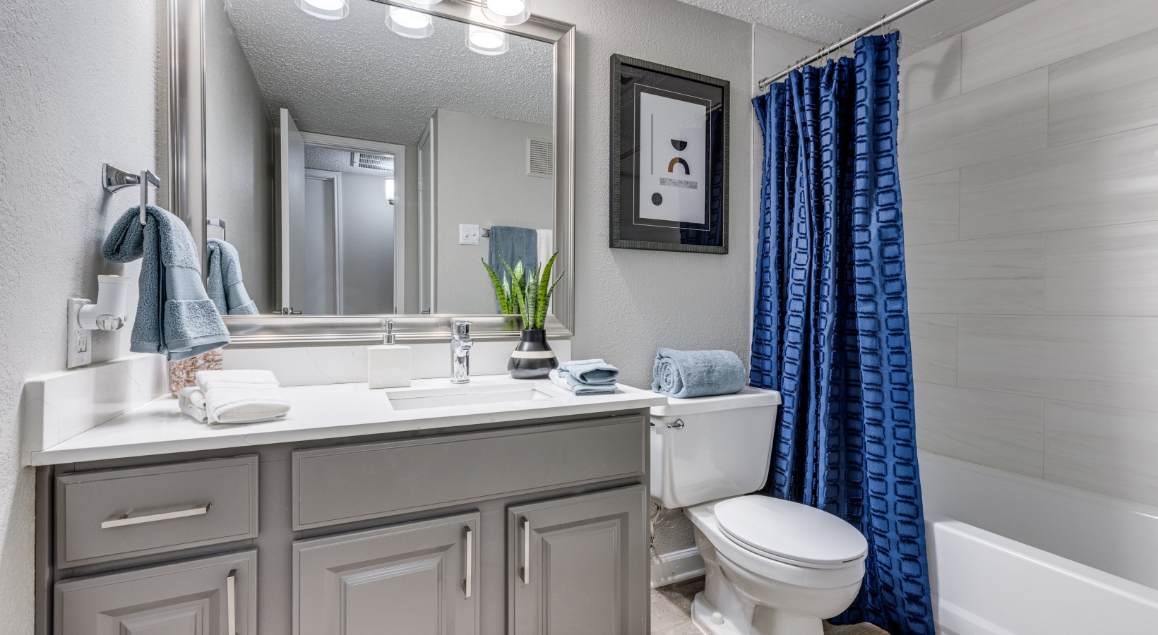 a bathroom with blue and white curtains and a white toilet at The  Dayton
