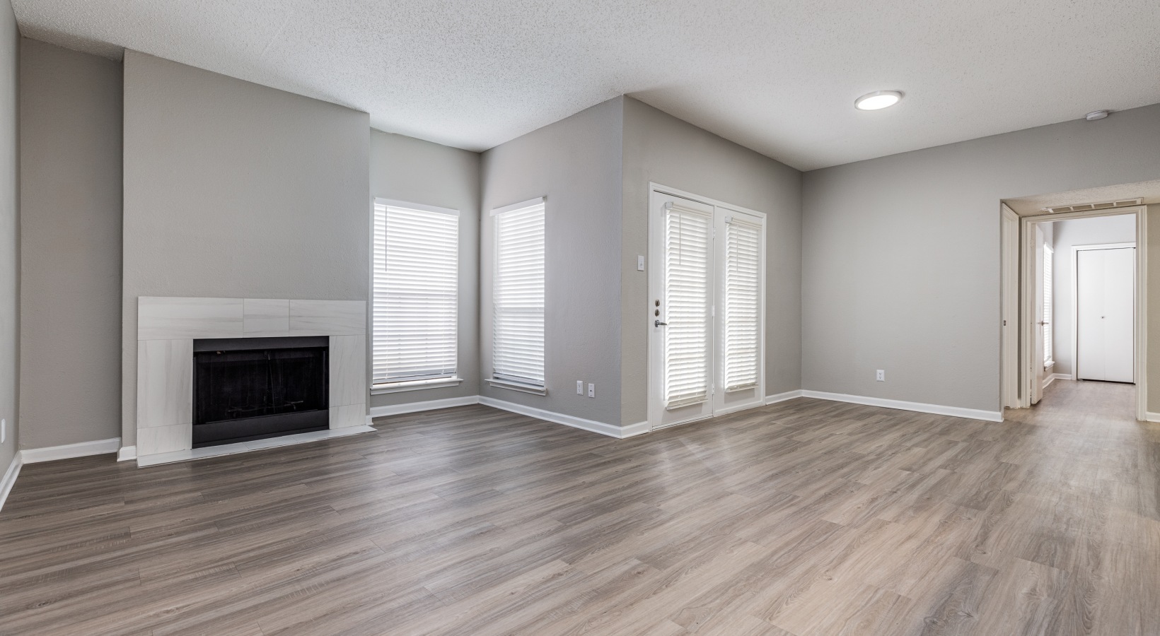 empty living room with hardwood floors and fireplace at The  Dayton