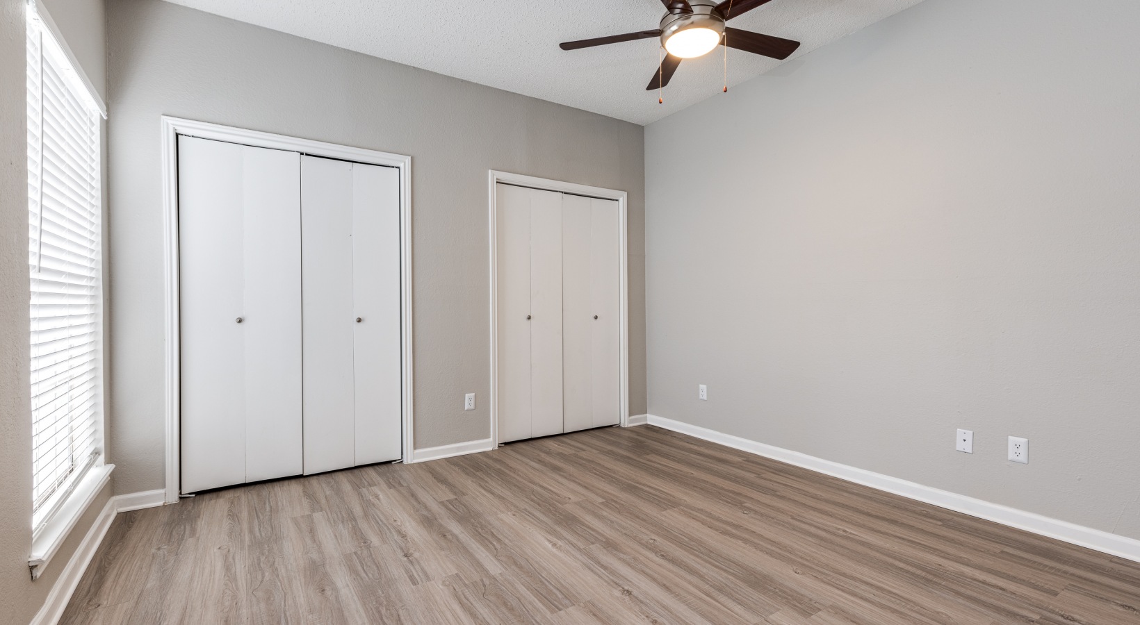 empty room with ceiling fan and hardwood floors at The  Dayton