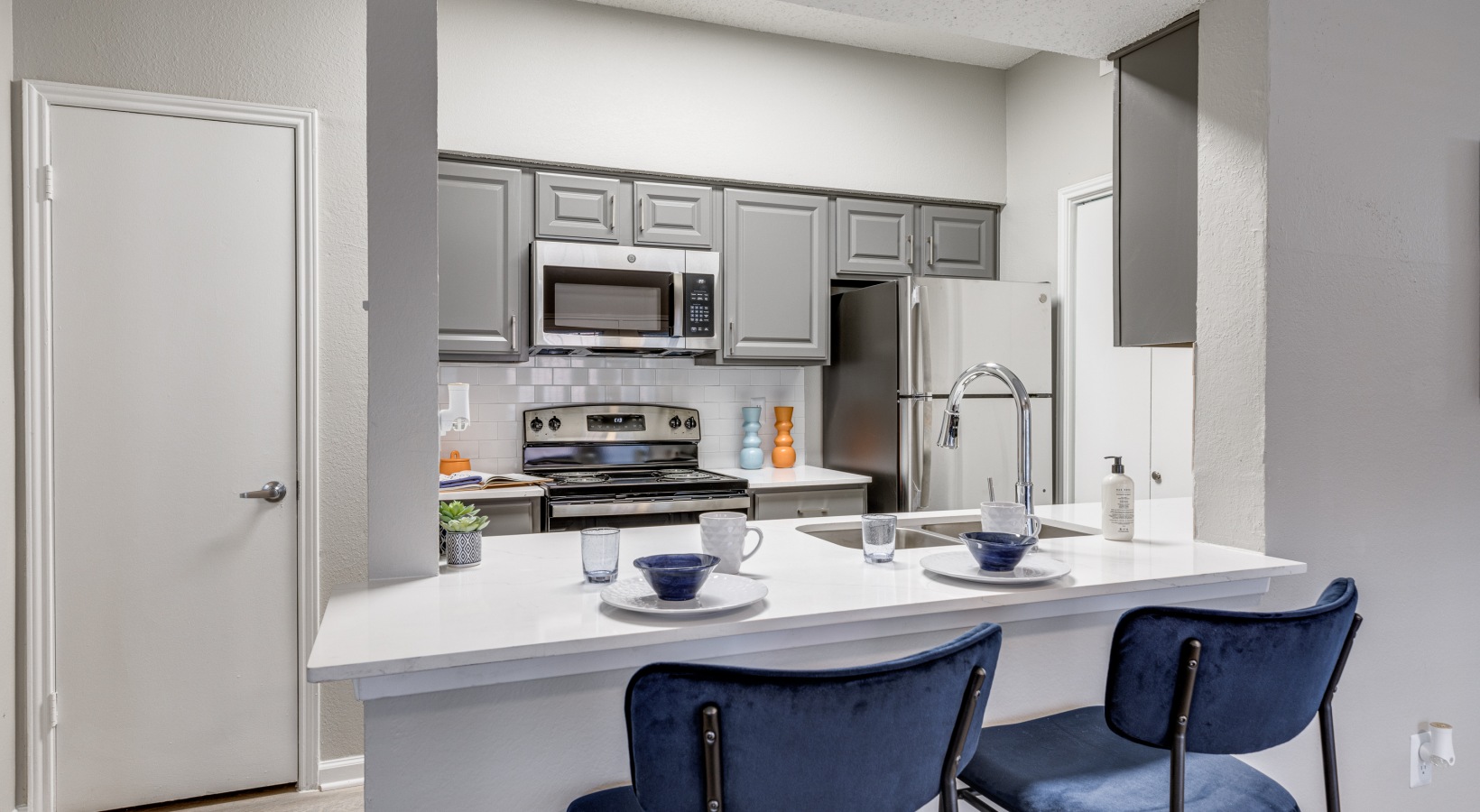 kitchen with stainless steel appliances and blue chairs at The  Dayton