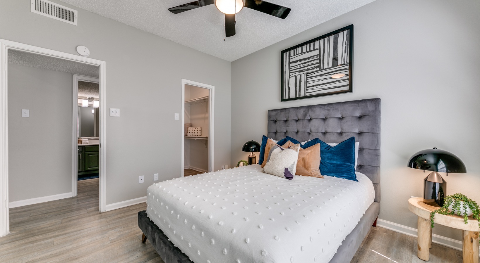 a bedroom with a ceiling fan and hardwood floors at The Dayton